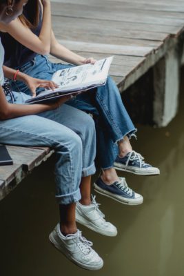 friends reading book on bridge